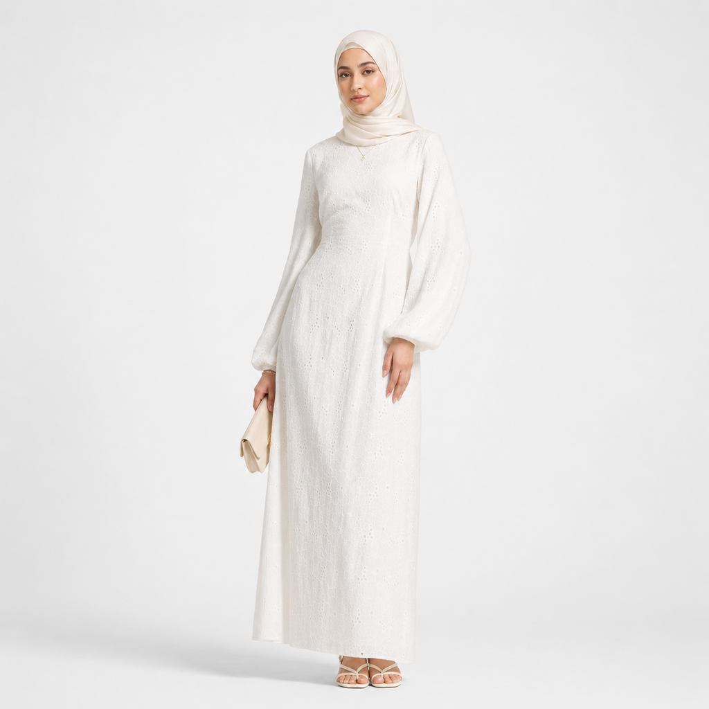 Woman wearing a white abaya and beige hijab on a white background