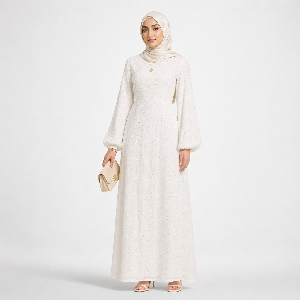 Woman wearing a long white dress and hijab on a light gray background