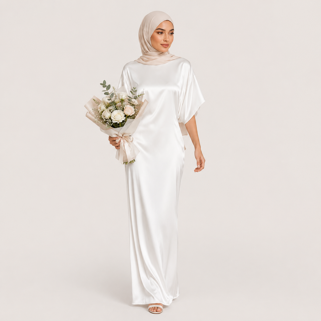 Woman in a white dress holding a bouquet of flowers on a plain background