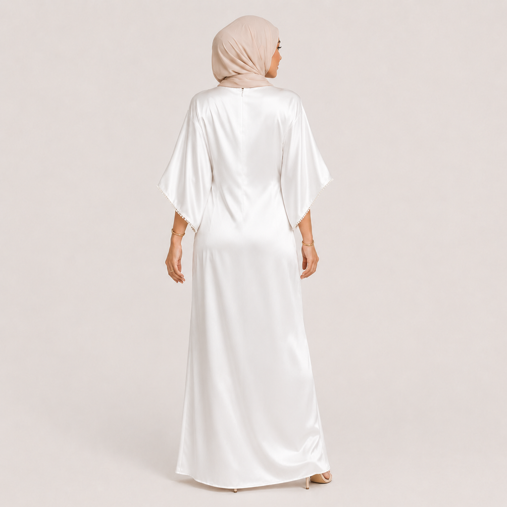 Woman wearing a white dress and beige hijab on a light pink background