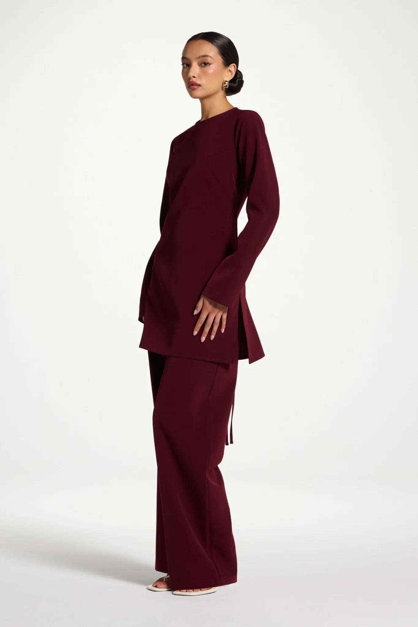 Woman wearing a burgundy outfit on a white background