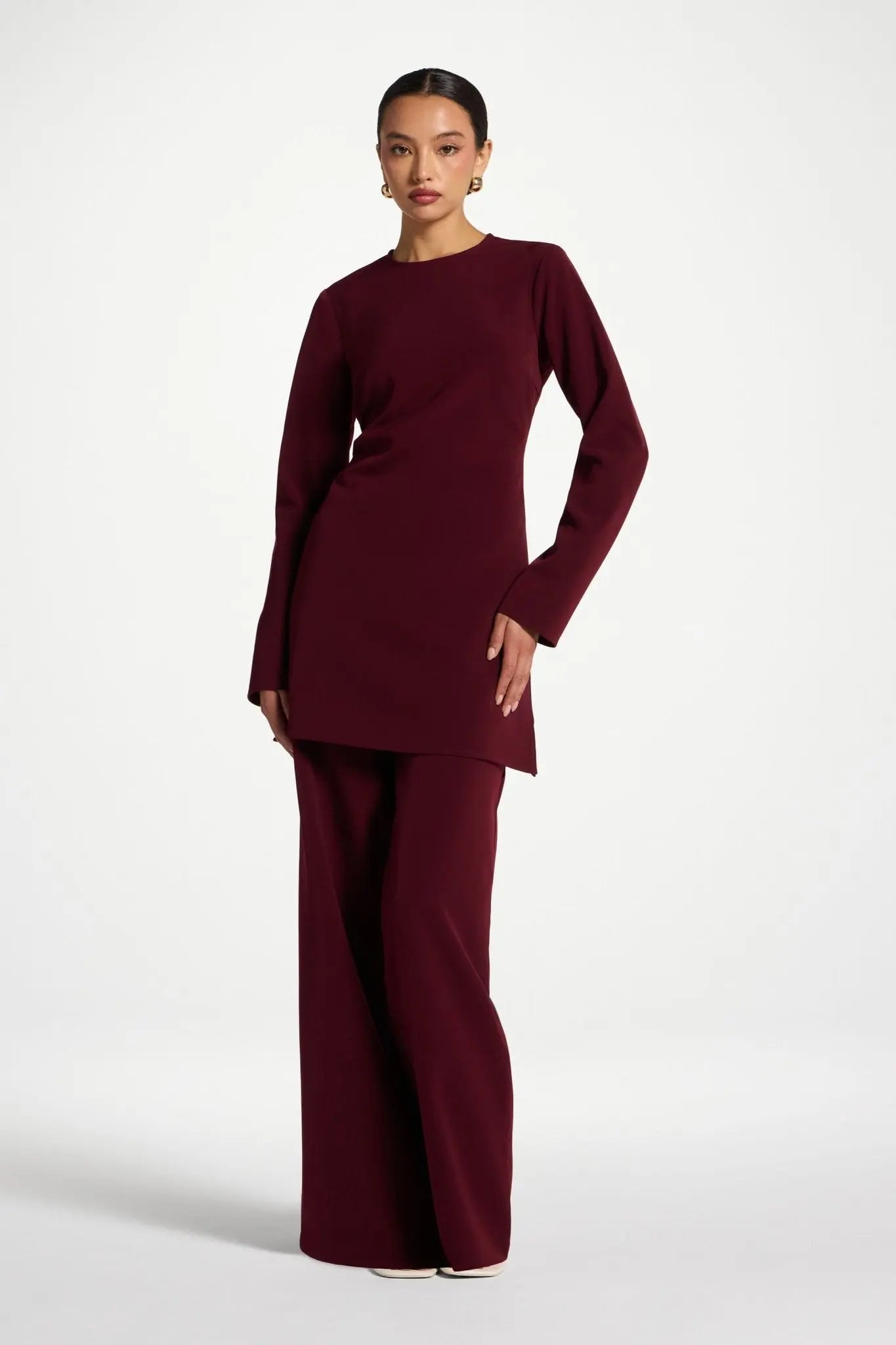 Woman wearing a burgundy outfit on a white background
